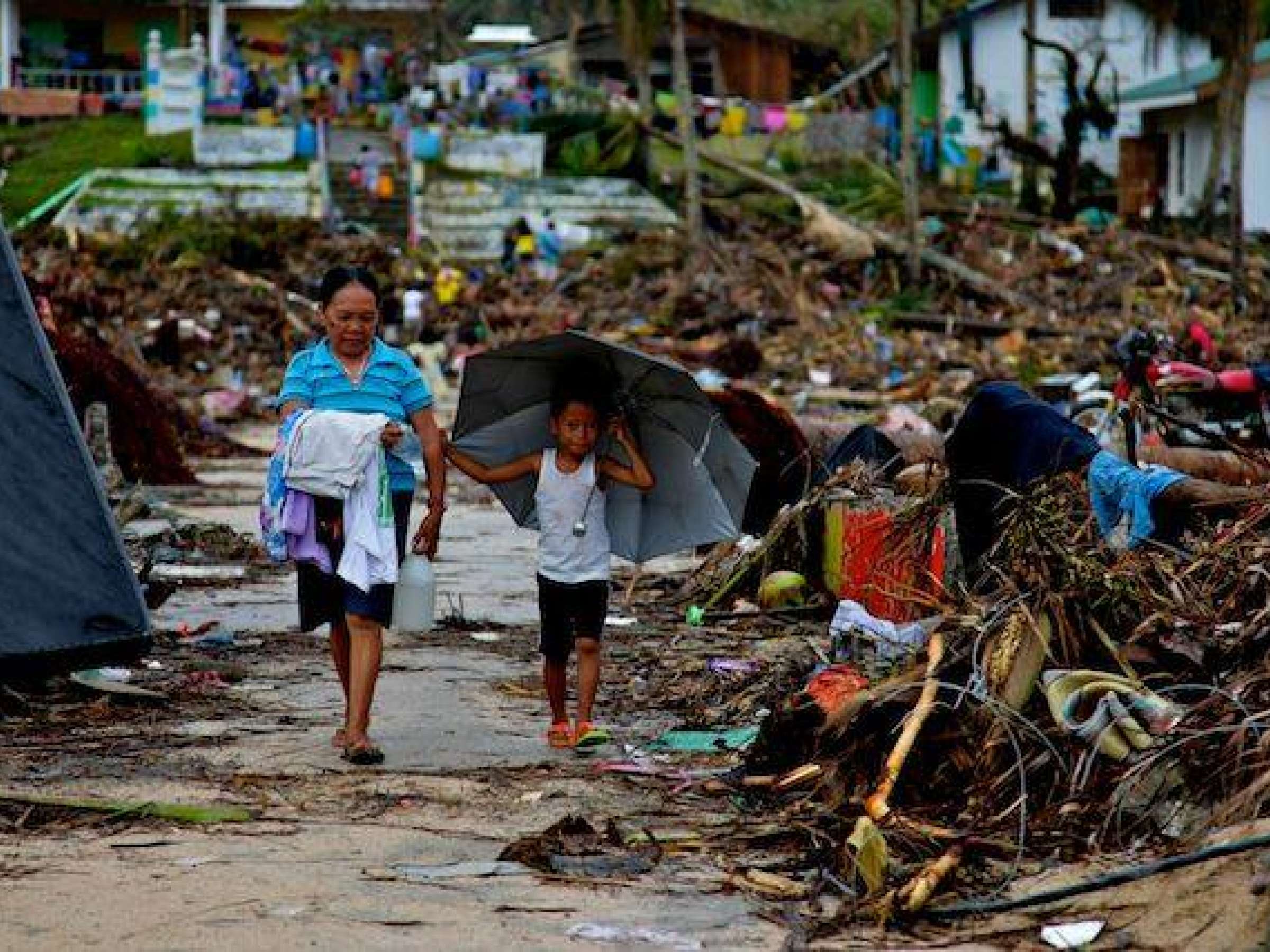 Residents walk past debris, East Samar, Philippines