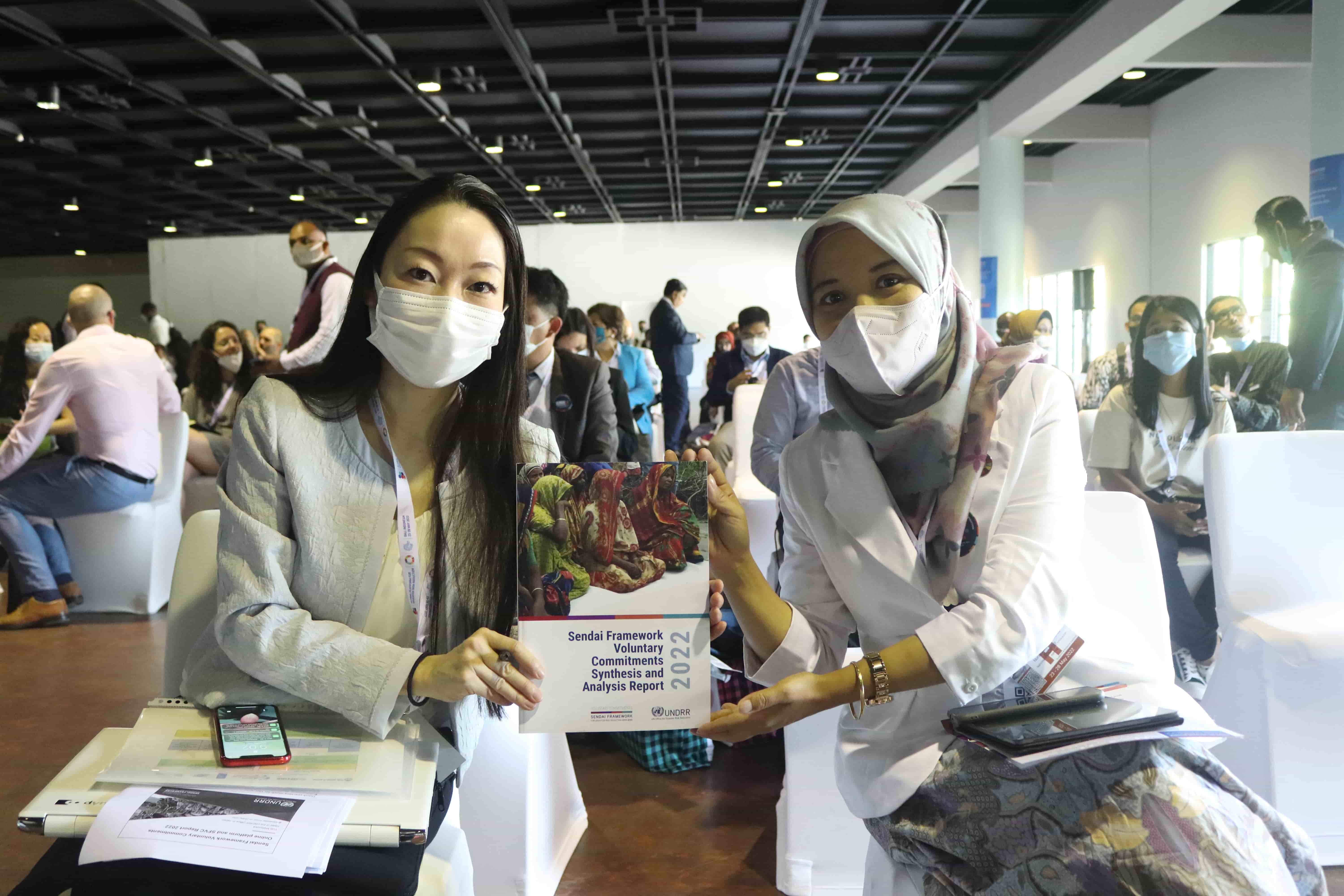 GP2022 participants holding the Sendai Framework Voluntary Commitments (SFVC) Synthesis Analysis Report 2022.