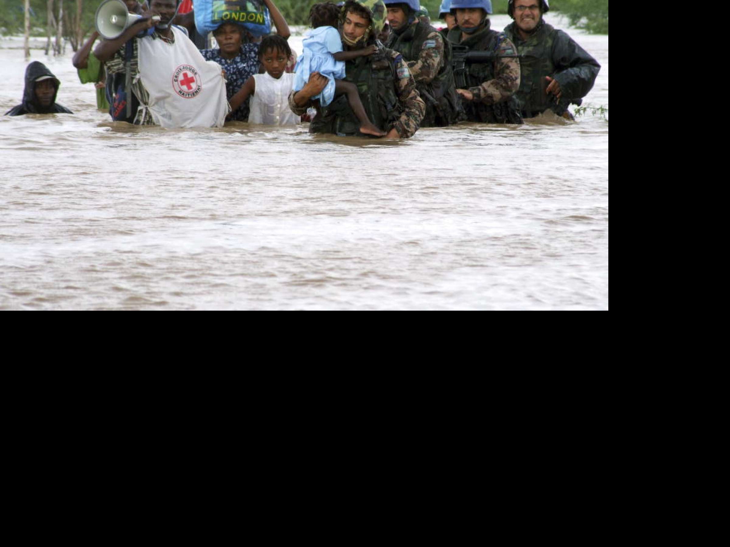 Members of the Jordanian battalion of the United Nations Stabilization Mission in Haiti (MINUSTAH) carry children through flood waters after a rescue from an orphanage destroyed by hurricane "Ike".