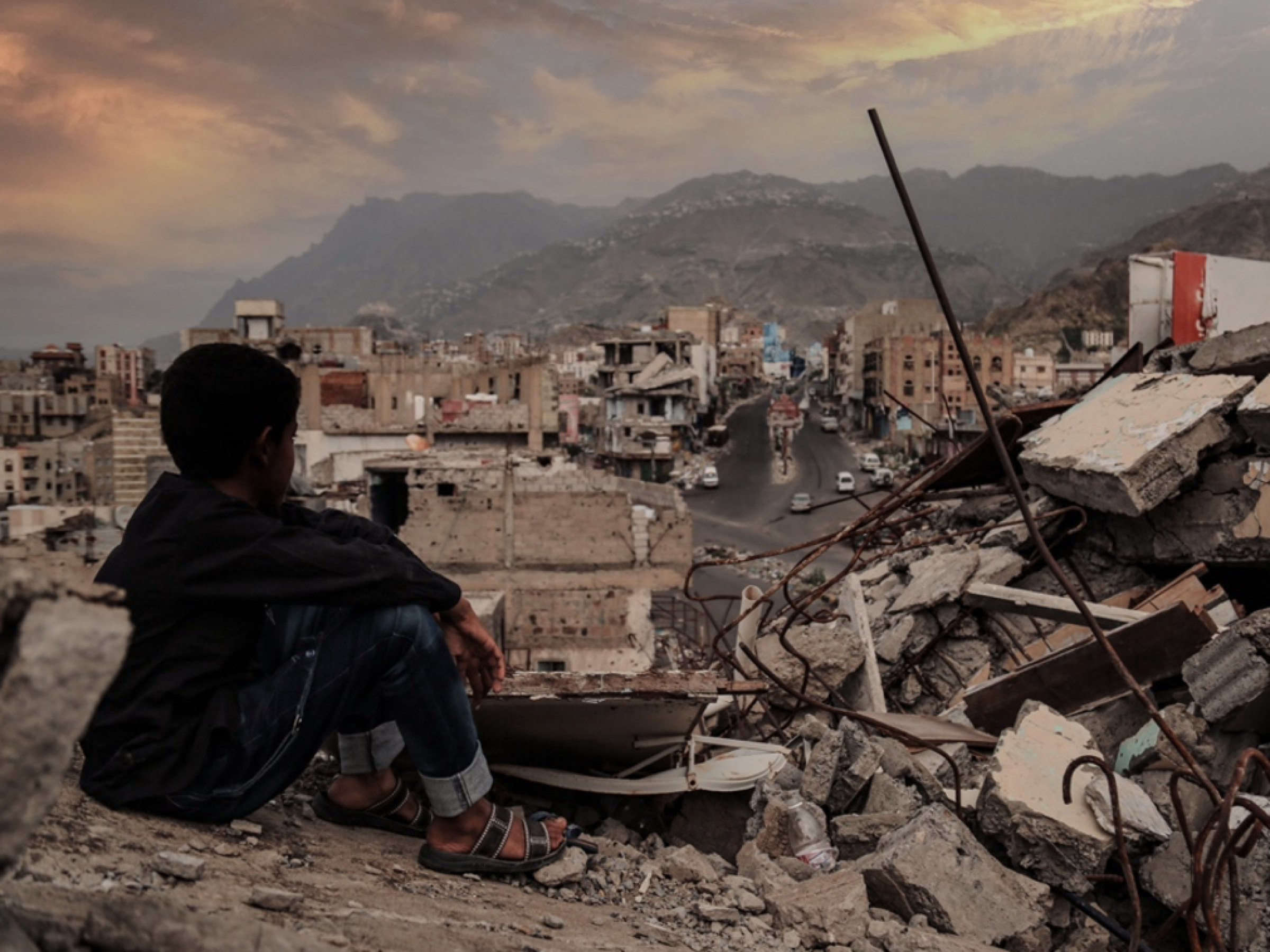 A child from Taiz City sits on the ruins of his ruined home because of the war on city-Yemen.