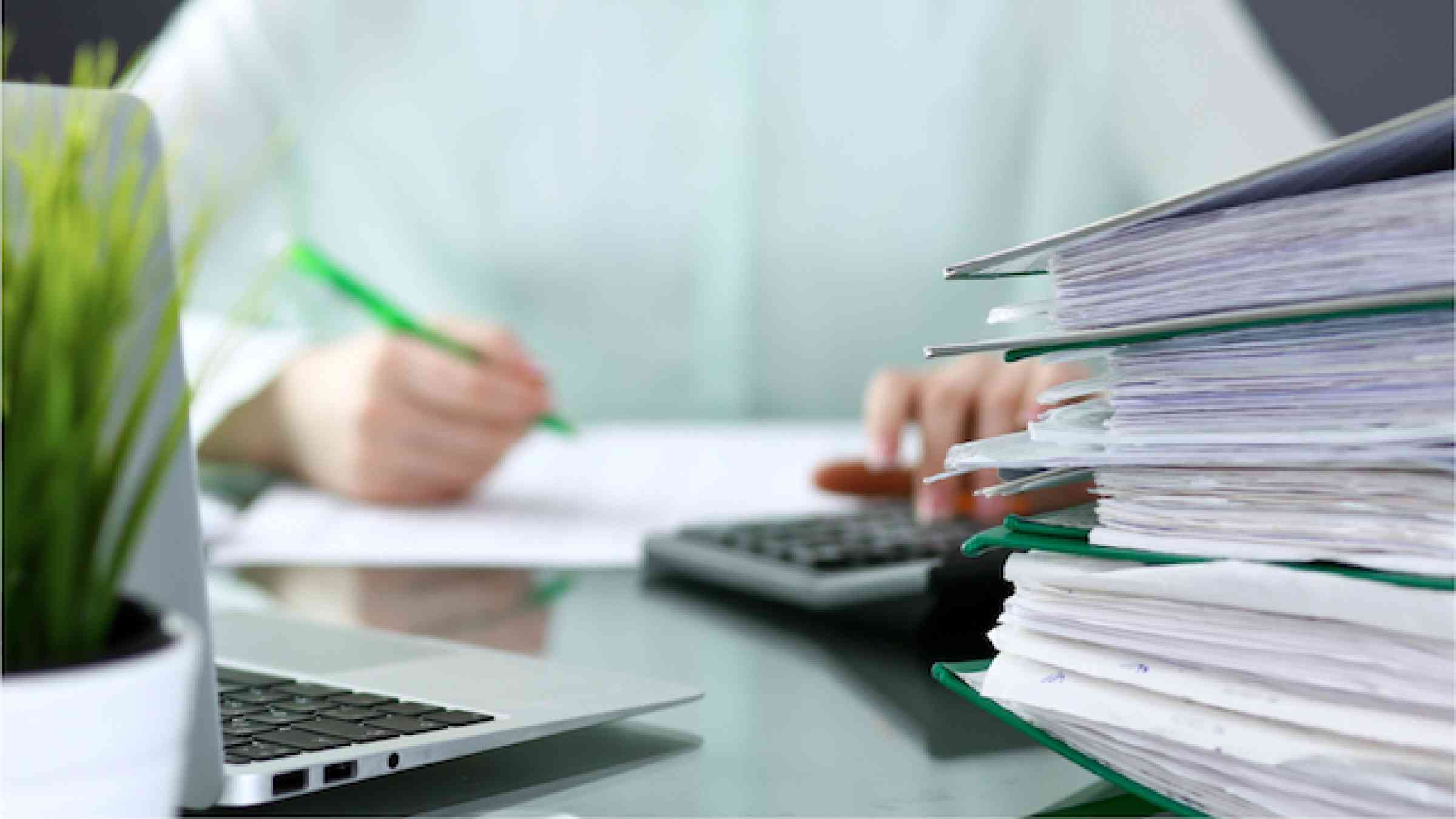 Bookkeeper or financial inspector making report, calculating or checking balance. Binders with papers closeup. 