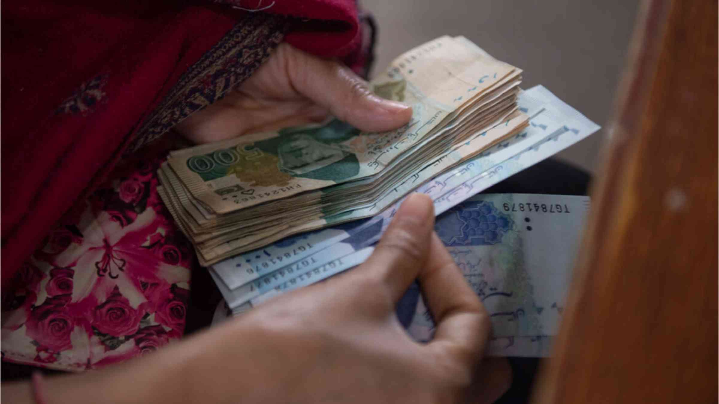 Women wait to receive cash of the governmental 'Ehsaas Emergency Cash Programme'