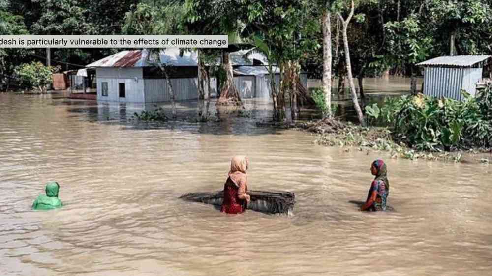 Bangladeshi women standing in a flooded street