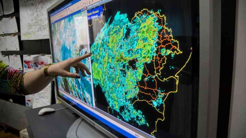 person pointing at weather map on a screen