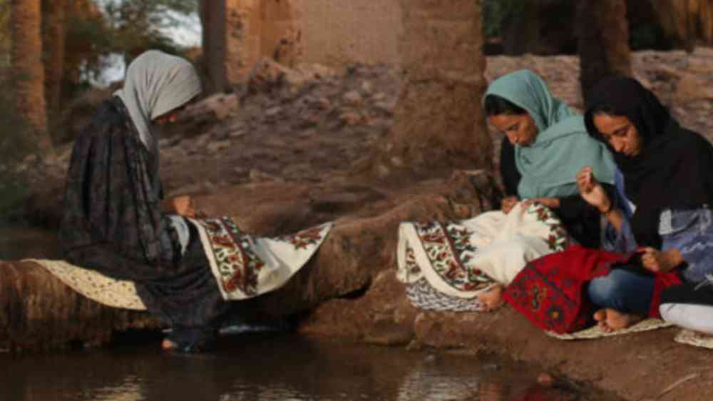Women sewing next to a quanat