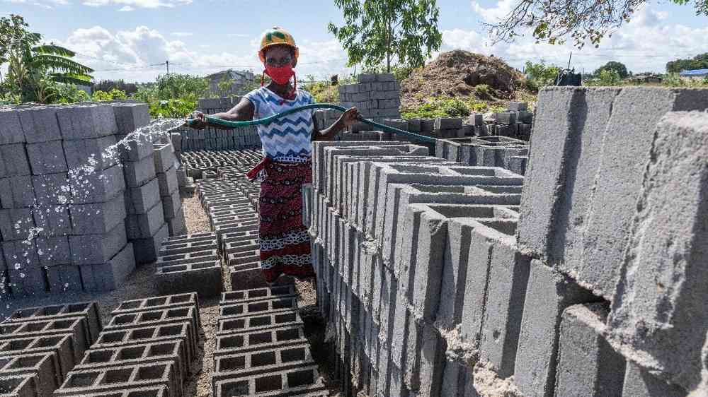 Construction worker wetting bricks in Mozambique