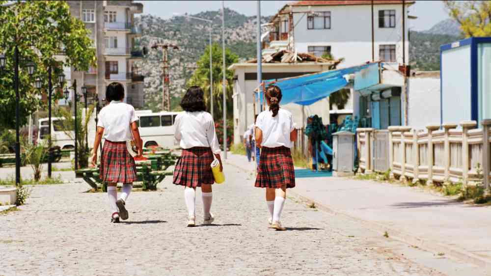 Three girls in uniform walking away